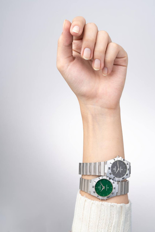 دو ساعت مچی زنانه امگا کانستلیشن بند استیل با صفحه سبز زمردی و مشکی، برای نمایش مقایسه رنگ در استایل روزمره